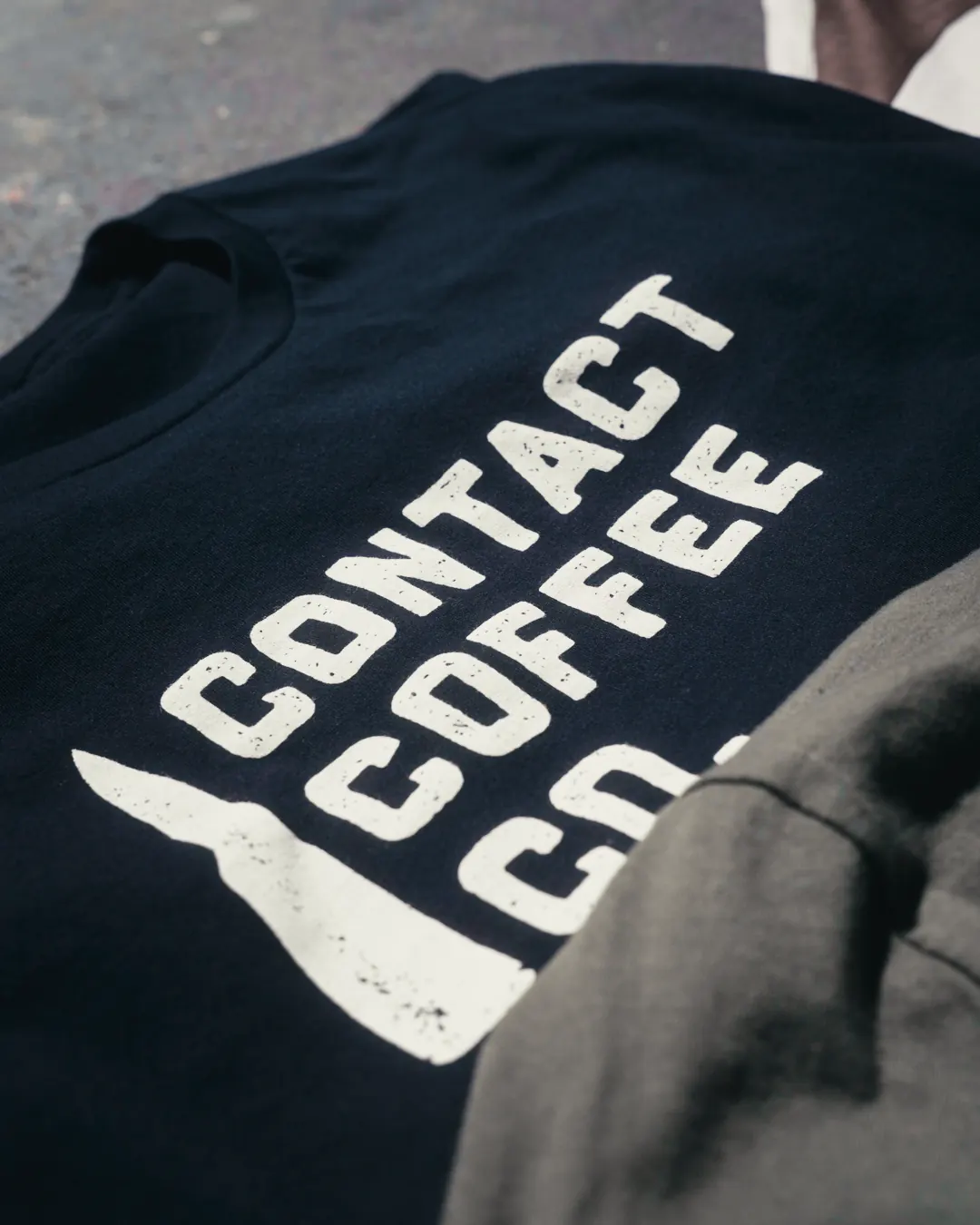Close detail of the navy Contact Coffee tee